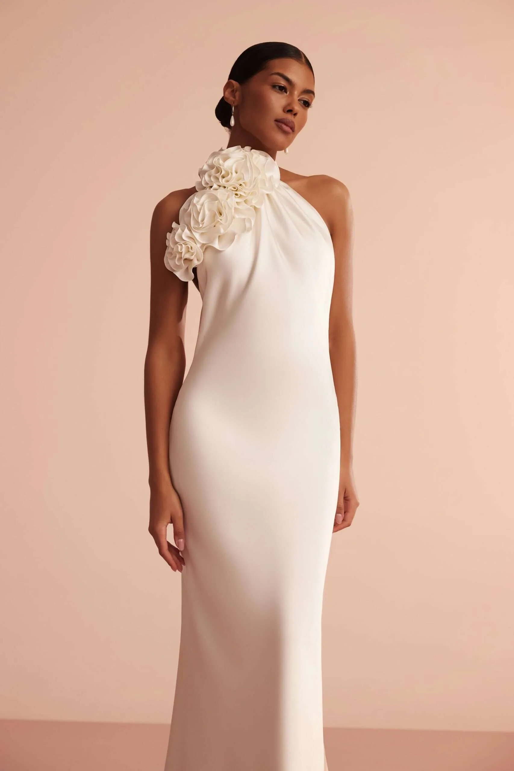 Close view of the folded fabric rose cluster resting on the shoulder and neckline