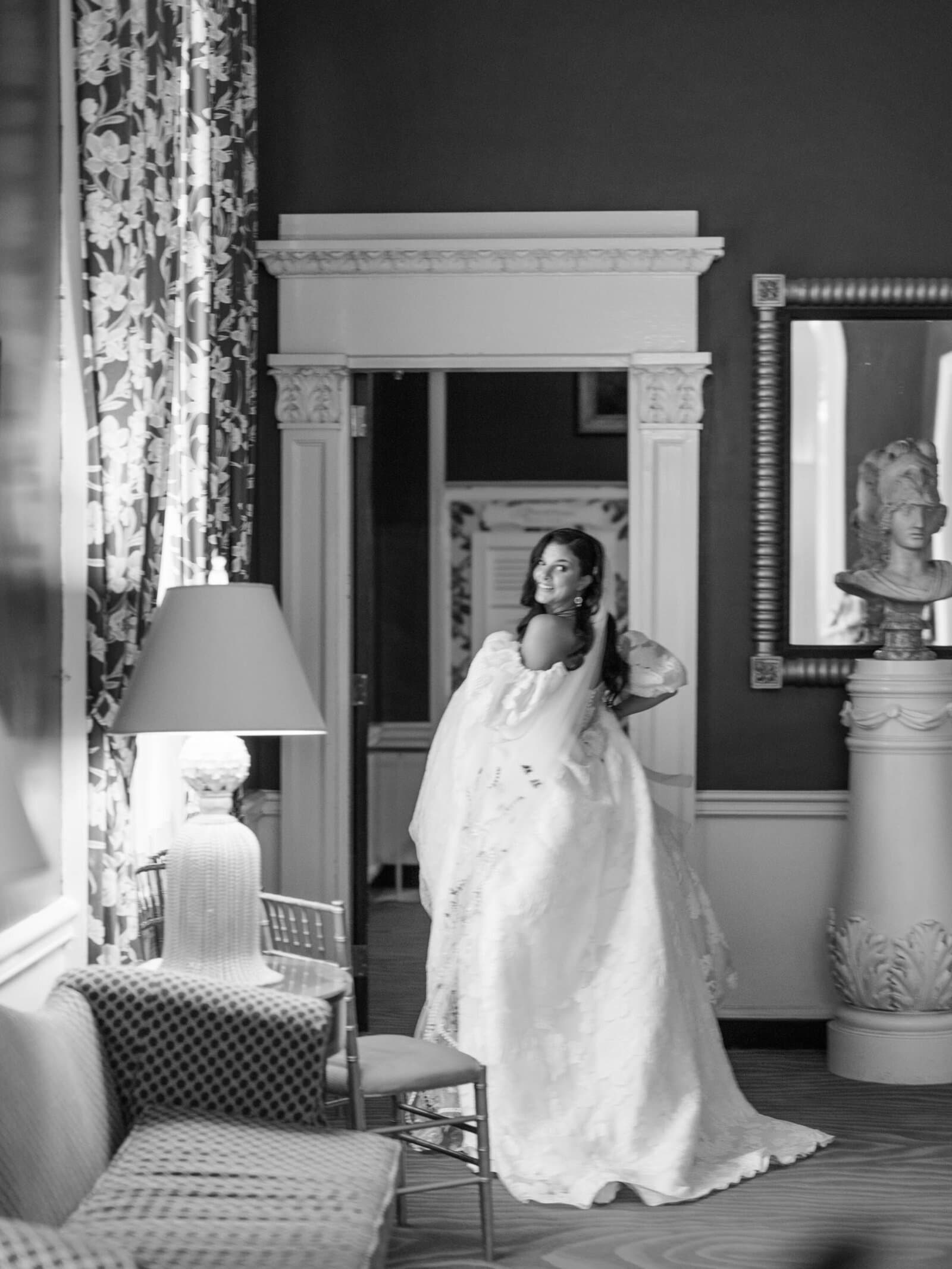 A bride in a voluminous gown looking back over her shoulder